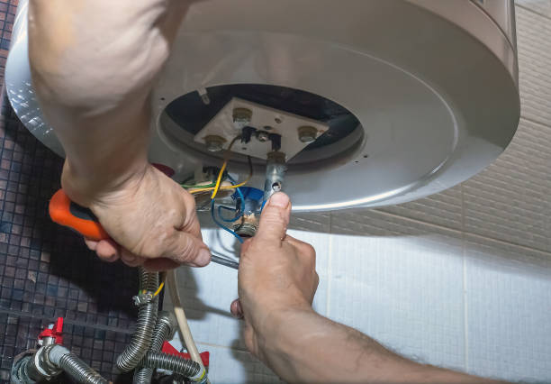 Repairman hand are fixing broken electric boiler Plumber man repairing electric boiler in bathroom. Repairman hand are fixing broken water heater replacement stock pictures, royalty-free photos & images