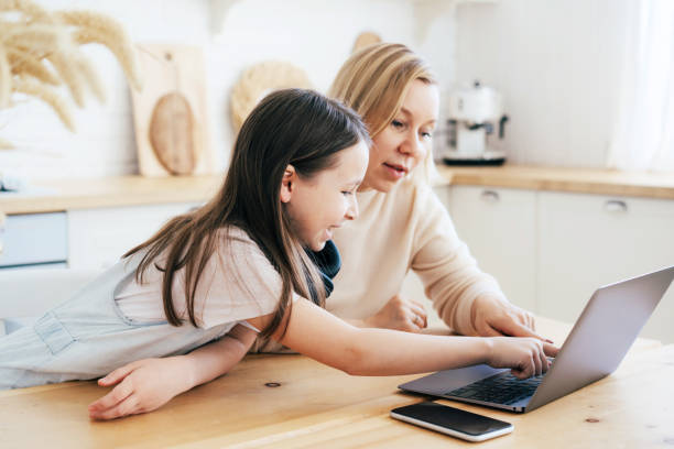 istock Mom and daughter surf in a laptop. 1296324436