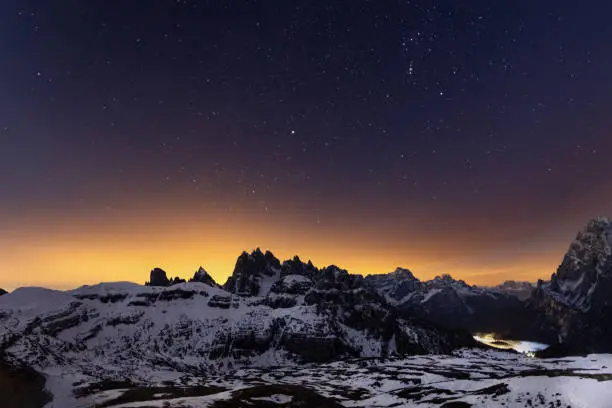 A picture of the Cadini di Misurina mountain range, under a night starry sky, near the Tre cime di Lavaredo and Cortina d'Ampezzo, in the Italian Dolomites