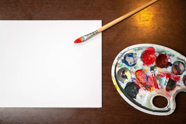 istock Paint brush laying on white black paper on wooden table. Copy space for text. 1296328242