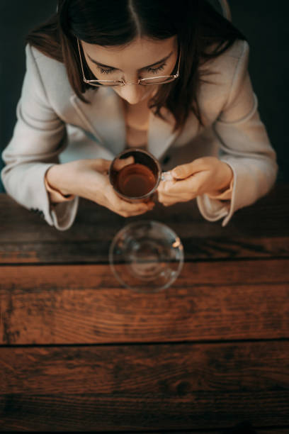 Aerial view of brunette sitting at the table in bar an holding cup of tea.