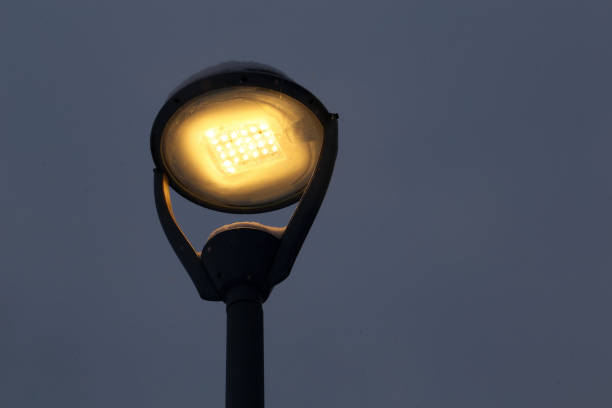 istock Glowing led lamp covered in snow on dark winter sky background during snowfall 1296331288