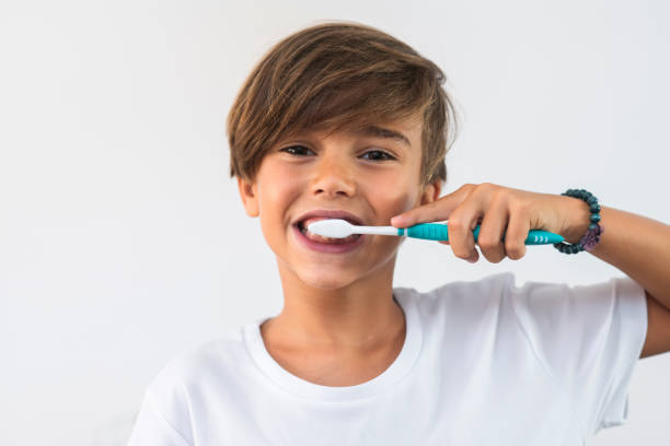 boy brushing his teeth isolated on white stock photo