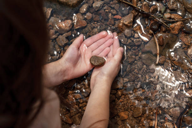 istock child's hands holding water, stones. 1296337965