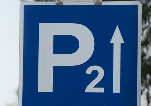 blue parking lot road sign with a white P letter