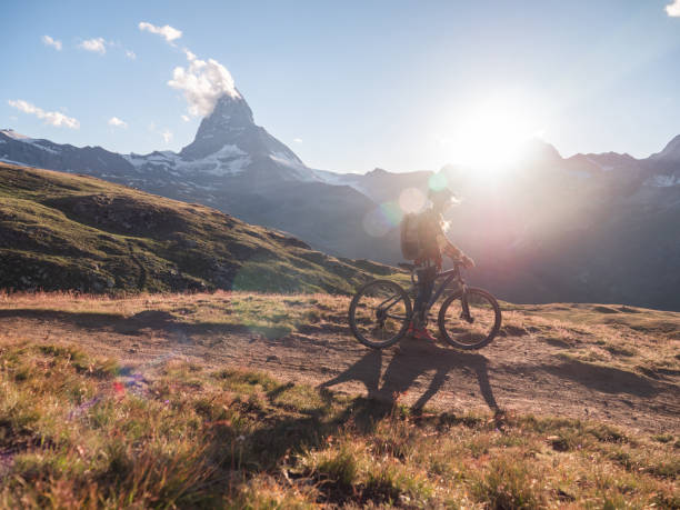 istock Female mountain biker admire the view from trail below the Matterhorn 1296340997