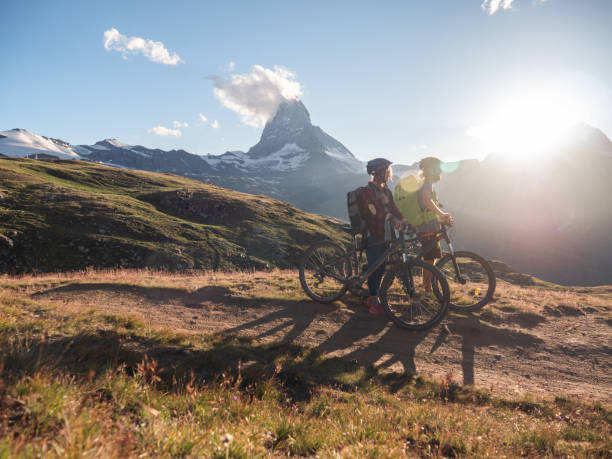 Mountain bikers pause on dirt trail to contemplate landscape