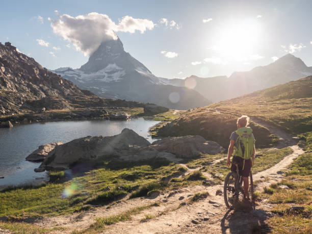 istock Man mountain biker rides along Lake below the Matterhorn mountain 1296342197