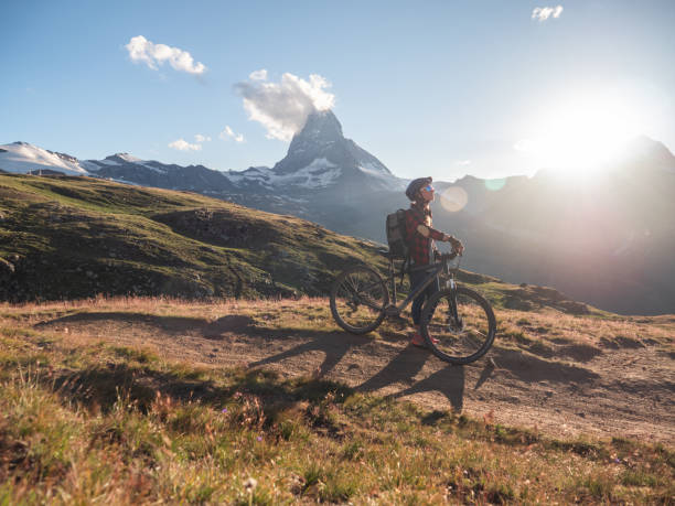 istock Female mountain biker admire the view from trail below the Matterhorn 1296342397