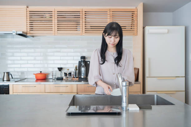 istock Woman washing dishes in the kitchen 1296349066
