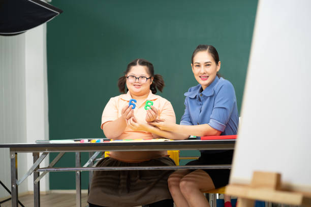 istock Asian disability kid and autism child learning arts in classroom with teacher 1296350075