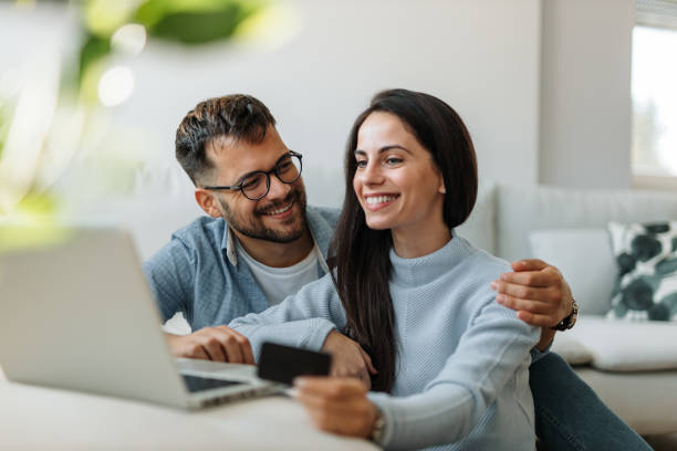 istock Holding card, looking at laptop. 1296350236