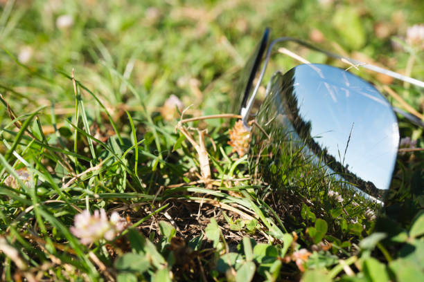 Sunglasses on the green grass. The glasses reflect a clear summer day with a beautiful landscape. Outdoor recreation concept
