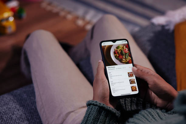 istock Man ordering food on mobile phone app at home 1296350398