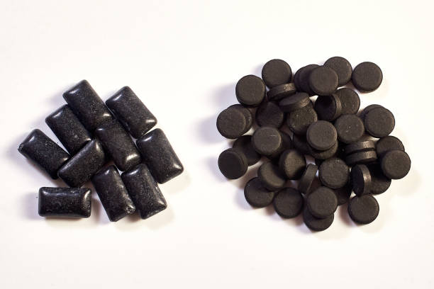 istock black chewing gum pads and black charcoal tablets on white background 1296351104
