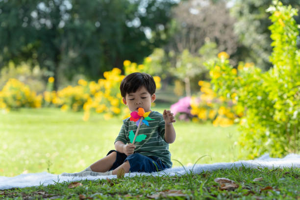 istock Asian little child having fun playing with windmill in the park 1296351644