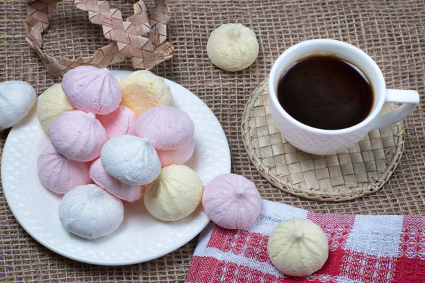 baisers faits maison de meringue et tasse de café. biscuits de meringue sur le fond naturel de sackcloth. - coffee sack photos et images de collection