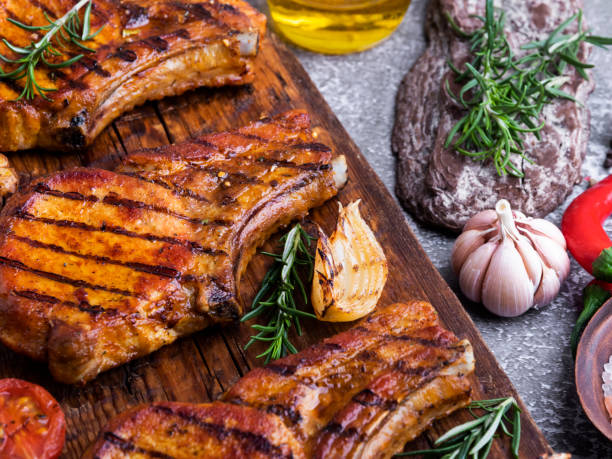 istock cooked grilled meat pork, beef, lamb, chop bone, cutting board spices tomato, rosemary 1296352658