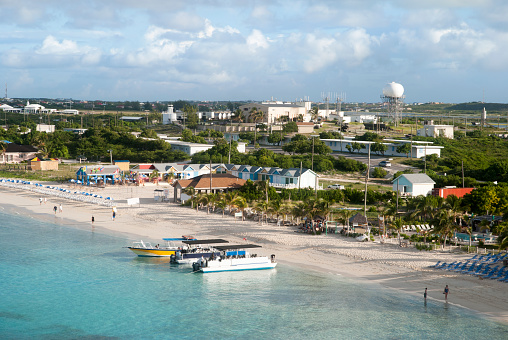 The aerial view of an empty tourist beach with industrial structures in a background on Grand Turk island (Turks and Caicos Islands).