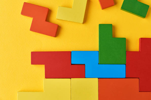 istock Different wooden blocks on yellow background. Concept of logical thinking and education 1296355377