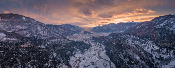 lever de soleil sur la vallée de lac de garde avec la neige, italie - water surface european alps mountain valley photos et images de collection