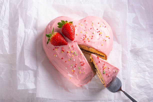 Heart shaped cake, pink color and strawberries.