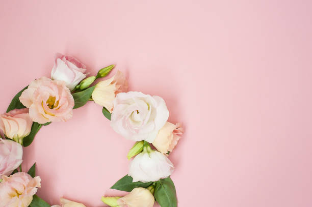 istock Creative layout made with pink flowers wreath on pastel pink background. Flat lay. Top view, frame with copy space 1296356864