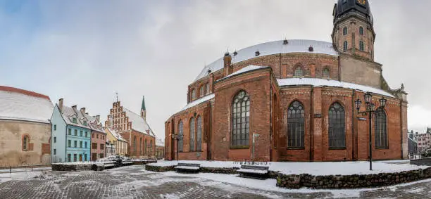 Panoramic view of St. Peter's Church and surrounded historical buildings in winter in old town in Riga, Latvia