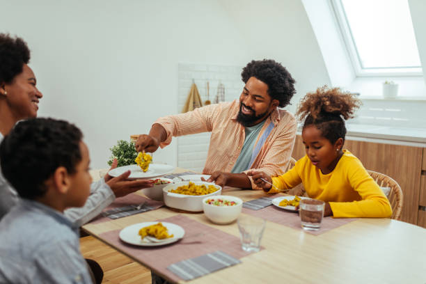 istock Afro family eating lunch together around the kitchen table 1296358080