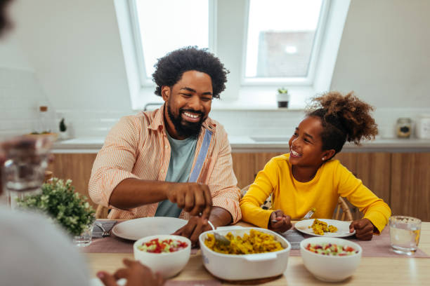 istock Afro father and daughter eating together at home 1296358085