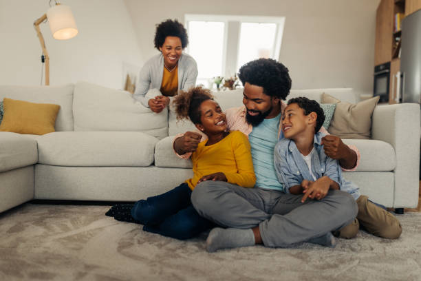 istock Afro parents and their children bonding at home 1296358093