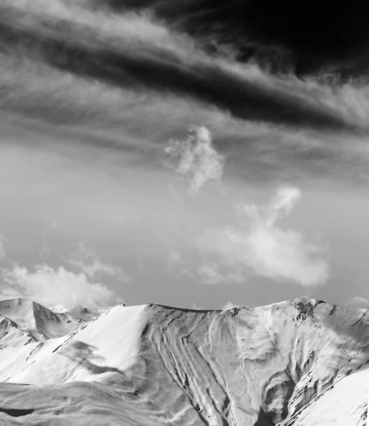 istock Black and white view on off-piste snow slope and sky with clouds 1296361157