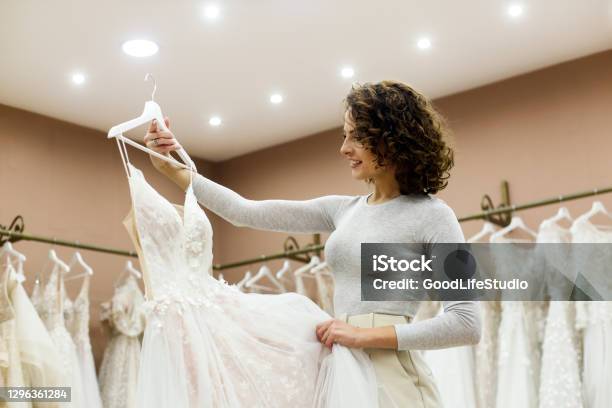 Young Woman Looking At A Wedding Dress In A Bridal Shop Stock Photo - Download Image Now