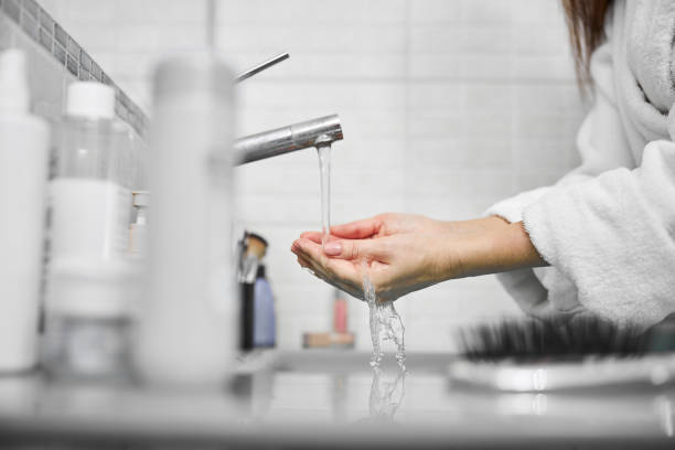 istock Female using cosmetics face cream in bathroom 1296361462