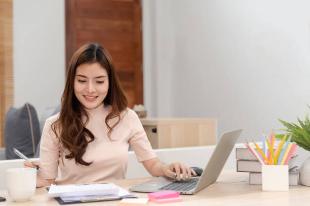 istock Work from home concept, a happy smiling beautiful Asian women Working at desktop computer laptop It is a new normal lifestyle of the online era. 1296361840