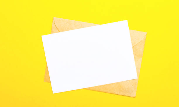 istock On a yellow-colored background, an envelope and a blank card with space to insert text or illustrations. Top view with copy space 1296363041