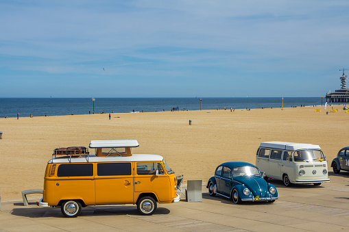 Scheveningen beach, the Netherlands - May 21, 2017: orange VW combi camper wagens and beetle at Aircooled classic car show