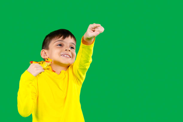 a preschool boy with a smile holds a lizard on his shoulder and points forward with his index finger. - iguana reptile smiling human face imagens e fotografias de stock