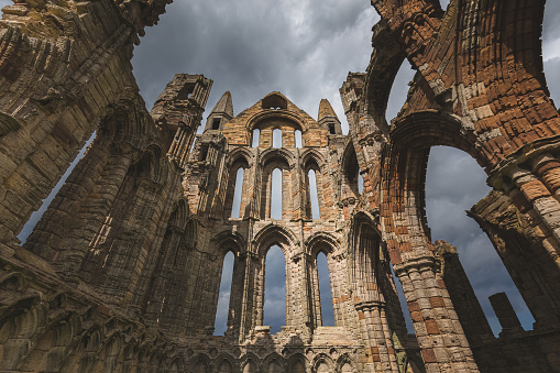 The historic 7th century ruins of Whitby Abbey perched atop East Cliff overlooking the North Sea in North York Moors National Park in North Yorkshire.