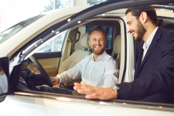 istock Car dealer showing automobile to client. 1296370876
