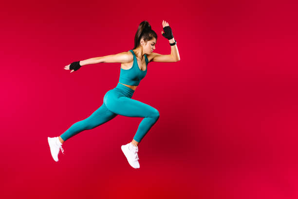 спортивная женщина бегун в силуэте на красном фоне. фотография привлекательной женщины в модной спортивной одежде. динамическое движение.  - dance company стоковые фото и изображения