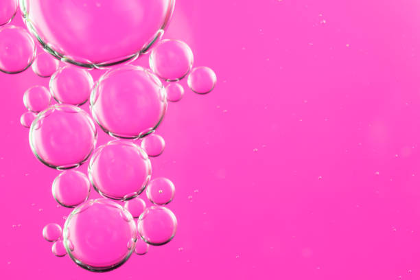 istock oil drops on water on a pink background 1296371969