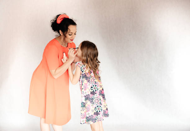 istock Mom paints her daughter's eyes. 1296372378