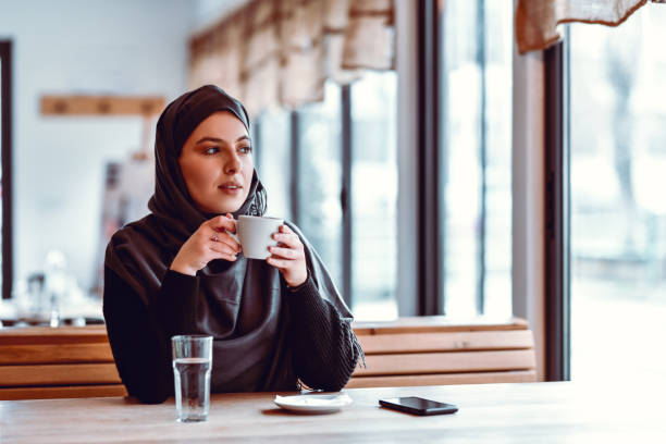 Coffee Time For Modern Muslim Female In Restaurant Coffee Time For Modern Muslim Female In Restaurant arab culture photos stock pictures, royalty-free photos & images