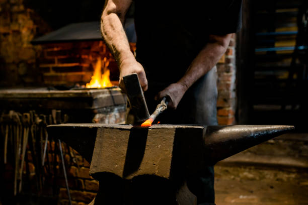 istock Blacksmith stands at the anvil and forges metal 1296377208