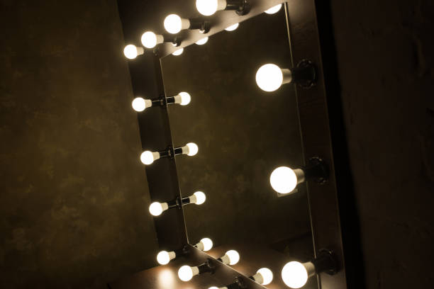 istock Antique mirror with lamps close up on black background 1296377516
