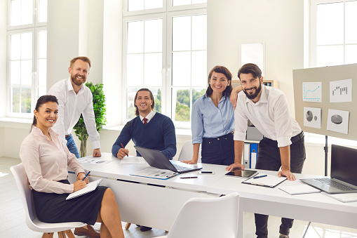 Office workers gathered in the conference hall to conduct research and implement new ideas. Cheerful business colleagues and partners in a meeting. Business, office and team work concept.