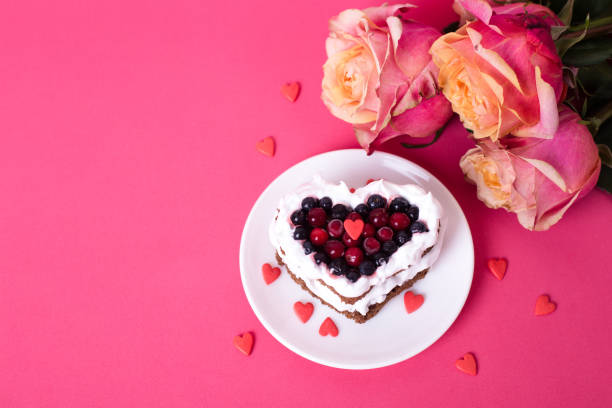 ピンクの背中に赤いカラントで飾られたハート型のケーキ - flower cake cookie food ストックフォトと画像