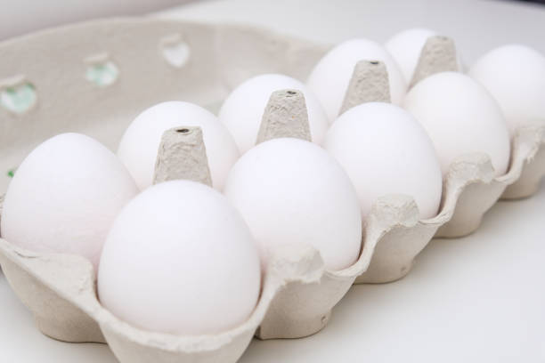 istock White eggs in recycled carton pressed box container on white table 1296379694