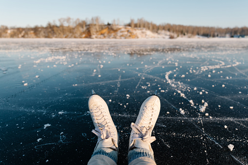 Skates close up on the ice of a frozen lake. Winter landscape, sunny day, atmosphere of fun winter activities